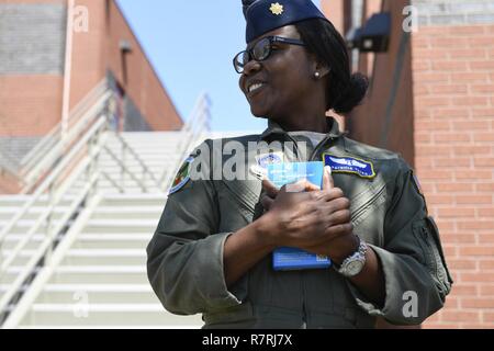 Le Major de l'US Air Force Patricia Yates, 156e Escadron d'évacuation aéromédicale, sourires et remerciements Girl Scouts de pays fournisseurs 20463 pour lui donner une boîte de biscuits au North Carolina Air National Guard Base, Charlotte Douglas International Airport, le 2 avril 2017. Les éclaireuses de Denver, N.C., a fait don de plus de 500 cases étiquetées avec des notes de remerciement personnel ainsi que plusieurs cas de cookies pour envoyer aux membres déployés outre-mer. Banque D'Images