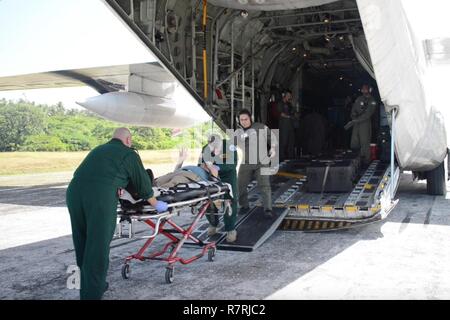 L'équipage de la Garde côtière canadienne d'aider le personnel des services d'urgence locaux dans le transport d'un patient à Queens Medical Centre à partir de la Coast Guard Air Station barbiers Point, Oahu, le 4 avril 2017. Le 74-year-old man est arrivé dans un état stable à Honolulu après avoir été évacué par un HC-130 Hercules avion à voilure fixe 1 061 miles de Atoll de Palmyra. Banque D'Images