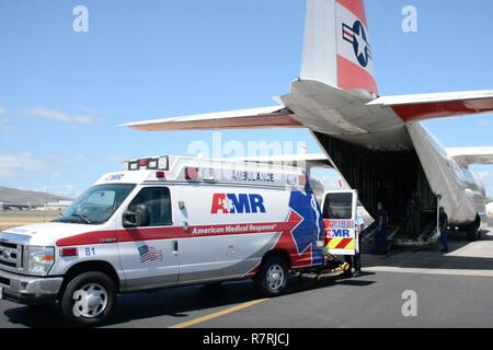 L'équipage de la Garde côtière canadienne d'aider le personnel des services d'urgence locaux dans le transport d'un patient à Queens Medical Centre à partir de la Coast Guard Air Station barbiers Point, Oahu, le 4 avril 2017. Le 74-year-old man est arrivé dans un état stable à Honolulu après avoir été évacué par un HC-130 Hercules avion à voilure fixe 1 061 miles de Atoll de Palmyra. Banque D'Images