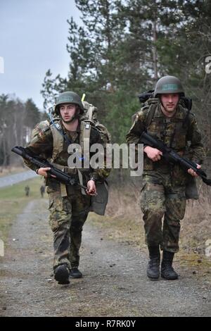 Deux soldats de l'Allemagne à un ruck mile 12 mars au cours de l'Armée américaine sur le terrain par les experts de l'Europe 2017 Badge médical (EFMB) concours, organisé par le 212e, 30e de l'Hôpital de soutien au combat de la brigade médicale, à la 7ème commande d'entraînement de l'Armée Formation Grafenwoehr, Allemagne, le 30 mars 2017. 215 candidats de 11 pays, s'efforcer de l'insigne au cours des cinq jours de défi. L'EFMB renforce la concurrence des compétences individuelles des soldats et renforce les liens avec les alliés et partenaires. Banque D'Images
