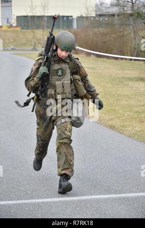 Un soldat allemand franchit la ligne d'arrivée après 12 km d'un ruck mars lors de l'armée américaine l'Europe sur le terrain par les experts 2017 Badge médical (EFMB) concours, organisé par le 212e, 30e de l'Hôpital de soutien au combat de la brigade médicale, à la 7ème commande d'entraînement de l'Armée Formation Grafenwoehr, Allemagne, le 30 mars 2017. 215 candidats de 11 pays, s'efforcer de l'insigne au cours des cinq jours de défi. L'EFMB renforce la concurrence des compétences individuelles des soldats et renforce les liens avec les alliés et partenaires. Banque D'Images