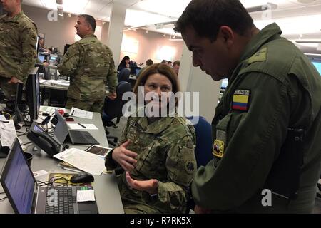 Le Lieutenant-colonel de l'armée de l'air colombienne Ernesto Gomez (à gauche) discute comment les demandes de soutien militaire sont traitées avec la Géorgie de la Garde nationale de l'Armée de l'Adjudant-chef 3 Julie Gamble à l'Agence de gestion des urgences de la Géorgie à Atlanta, en Géorgie, au cours d'une visite de l'état d'opérations d'urgence le 30 mars 2017. Gomez, et quatre autres officiers de l'armée colombienne, ont passé la semaine à visiter plusieurs sites au cours de l'exercice avec le gardien vigilant de la Caroline du Sud Garde Nationale comme une partie de l'État Programme de partenariat. Banque D'Images