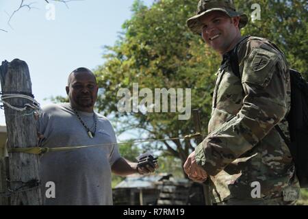 Le sergent de l'armée américaine. Ryan Mills, un réserviste affecté à des opérations de soutien d'information militaire 344Company (Airborne) une unité de réserve de Austin, Texas, informe un Ladyville Belize, un local de services médicaux gratuits cas fournis par l'exercice au-delà de l'horizon 2017. Mills est un voyage à travers les sections locales pour sensibiliser Ladyville sur les services médicaux gratuits les événements qui seront une partie de au-delà de l'horizon 2017, un exercice de partenariat entre U.S. Southern Command et le gouvernement du Belize qui fournira trois événements libres et cinq projets de construction throughou Banque D'Images