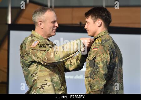 L'ARMÉE AMÉRICAINE L'Europe Général Commandant adjoint, Brig. Le général Phillip S. Jolly, gauche, prix l'expert médical de terrain (EFMB Badge) à un soldat allemand pendant l'EFMB cérémonie de remise des prix au 7e commandement de l'instruction de l'armée, Grafenwoehr, Allemagne, le 30 mars 2017. 215 candidats de 11 pays, s'efforcer de l'insigne au cours des cinq jours de défi. L'EFMB renforce la concurrence des compétences individuelles des soldats et renforce les liens avec les alliés et partenaires. Banque D'Images