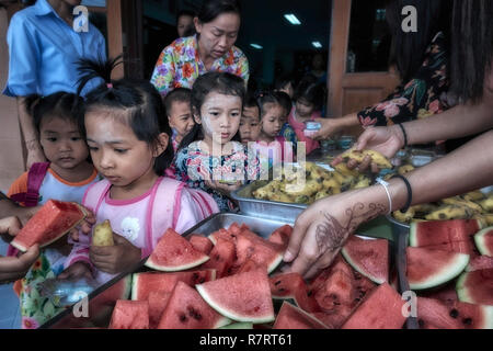 Centre de garde d'enfants pour les enfants défavorisés avec des aides donnant de la nourriture aux enfants. Thaïlande Asie du Sud-est Banque D'Images