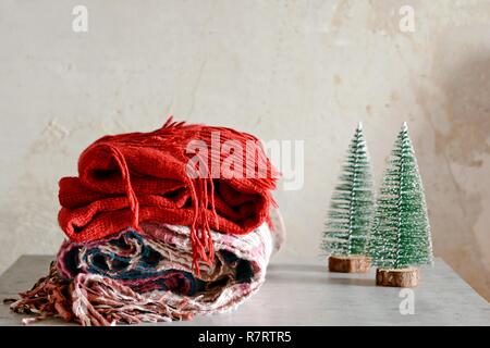 Une pile de vêtements chauds sur la table. Ambiance de Noël à la Chambre. Salle décorée de branches de sapin avec les cônes. Style de vie. Automne ou hiver stil Banque D'Images