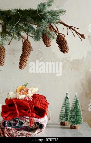 Une pile de vêtements chauds sur la table. Ambiance de Noël à la Chambre. Salle décorée de branches de sapin avec les cônes. Style de vie. Automne ou hiver stil Banque D'Images