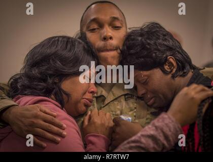 Réserve de l'armée américaine 1ère classe privée Torrence Saunders, de l'Atlanta, Géorgie, un photographe avec Det. 5, Caméra de combat 982e Airborne (Co.), réconforte sa mère et sa tante lors de son déploiement dans la 335e cérémonie de la commande Signal (Théâtre) à East Point, Géorgie, le 7 mars 2017. Le détachement a été de se lancer dans un déploiement de neuf mois pour le Moyen-Orient à l'appui de la Force opérationnelle interarmées - Fonctionnement résoudre inhérent, la coalition internationale composée de forces militaires des États-Unis et de plus de 30 pays établi pour vaincre ISIL en Syrie et en Irak. Banque D'Images