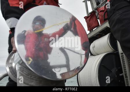 Maître de 2e classe Garrett Hamilton, un maître de manœuvre affecté à la station de la Garde côtière canadienne Bodega Bay, Californie, démontre une bonne ligne d'attrape à l'utilisation des sacs de voile membres d'équipage à bord d'un bateau de sauvetage à moteur de 47 pieds, 6 avril 2017. Le scénario de formation faisait partie d'un équipage de bateau, de deux semaines de la station du Collège a accueilli de nouveaux membres. Banque D'Images