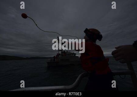 Seaman Julia Harris, un membre d'équipage de la Garde côtière à Bodega Bay, en Californie, les prises d'une ligne d'attrape flottante à bord d'un bateau de sauvetage à moteur de 47 pieds au cours de la formation de l'équipage du bateau, le 6 avril 2017. Harris a été parmi les six membres d'équipage en remplissant et en classe en cours de formation pour devenir des membres d'équipage de bateaux qualifiés à la gare. Banque D'Images