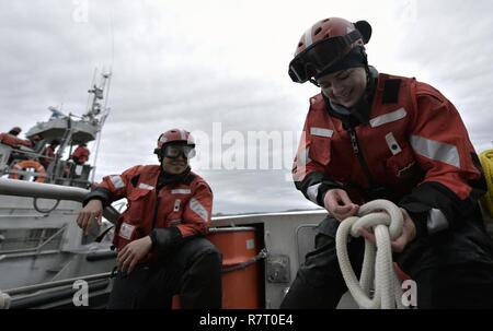 Seaman Julia Harris, un membre de l'équipe de Coast Guard Station Bodega Bay, Californie, apprend à faire un nœud à bord d'un bateau de sauvetage à moteur de 47 pieds au cours d'équipage de bateau, formation de matelotage, le 6 avril 2017. La formation faisait partie d'un programme de deux semaines visant à créer des compétence de l'équipage du bateau parmi les membres nouvellement déclarés. Banque D'Images