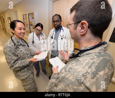 U.S. Air Force Le Major Andrew Maley, 88e Escadron d'opérations médicales medical médecin traitant, examine le plan de soins pour un patient avec le capitaine de l'US Air Force Le Diana (à gauche), 88e ODM medical médecin résident, Denisa Jacobs (milieu) Réseau Santé Kettering étudiant, et Faysal Abdille (droite), résident en médecine, à l'intérieur du centre médical sur la base aérienne de Wright-Patterson, Ohio, le 7 avril 2017. L'IPTS 88e prend en charge six programmes Graduate Medical Education, 13 spécialités médicales chirurgie avec 12, la défense de la patrie et plate-forme de déploiement. Banque D'Images