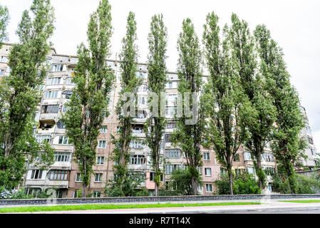 Rivne, Ukraine Kiev City dans l'ouest de l'Ukraine parc extérieur en été avec de grands arbres verts et ancien immeuble d'architecture soviétique Banque D'Images