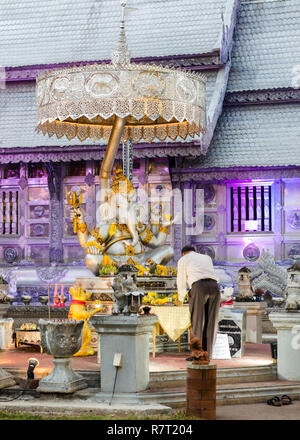 Thai man prier et faire une offrande avant de Ganesha statue au Wat Sri Suphan ou d'argent, temple Chiang Mai, Thaïlande Banque D'Images