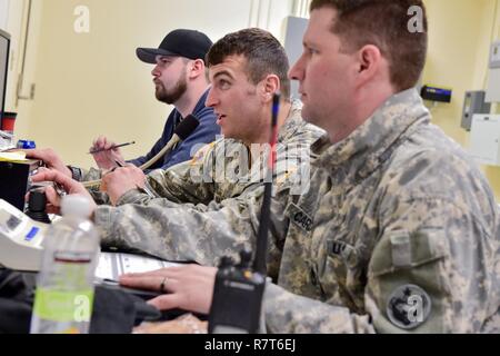 Rodney Lengele, gauche, un opérateur sur ordinateur pour le choix de la formation, de l'Armée 2e lieutenant Jacob Maechler, armée et le Sgt. 1re classe Justin Cardoza, les soldats affectés à la 95e compagnie de produits chimiques, de l'Arctique "dragons", 17e Bataillon de soutien au maintien en puissance de combat de l'armée américaine, l'Alaska, s'assurer que l'éventail est évident lors d'une pause dans un exercice de tir réel de tir avec M1135 Stryker Véhicules de reconnaissance nucléaire, biologique et chimique sur Joint Base Elmendorf-Richardson, Alaska, le 5 avril 2017. L'épreuve de tir à l'identification des compétences du soldat, engagement, et d'éliminer des cibles hostiles tandis que increasi Banque D'Images