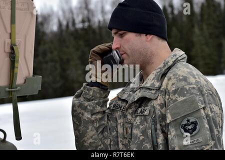 Lieutenant de l'Armée de Jacob Maechler, originaire de Mena, Ark., affecté à la 95e compagnie de produits chimiques, de l'Arctique "dragons", 17e Bataillon de soutien au maintien en puissance de combat de l'armée américaine, l'Alaska fait une radio (avant un exercice de tir réel de tir avec M1135 Stryker Véhicules de reconnaissance nucléaire, biologique et chimique sur Joint Base Elmendorf-Richardson, Alaska, le 5 avril 2017. L'épreuve de tir à l'identification des compétences du soldat, engagement, et d'éliminer des cibles hostiles tout en augmentant l'efficacité au combat. Le NBCRV Styker fournit des armes nucléaires, biologiques et chimiques pour le champ de bataille de détection et surveillance Banque D'Images