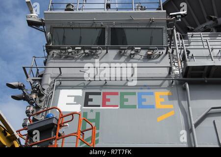 Plage de sable blanc, l'Okinawa (6 avril 2017) matelot timonier, Daija Anderson, de Houston, peint un "E" sur la superstructure du navire d'assaut amphibie USS Bonhomme Richard (DG 6) pour indiquer la commande's 2017 Award de l'efficacité de combat (battle "E"). Le Commandement des forces de surface (COMSURFOR) Bataille "E" est décerné annuellement au meilleur des navires dans la flotte de l'Atlantique et du Pacifique, et reconnaît une commande pour sa performance supérieure. Bonhomme Richard, navire amiral du Bonhomme Richard groupe amphibie, est sur une patrouille, opérant dans la région du Pacifique-Indo-Asia warfight pour améliorer Banque D'Images