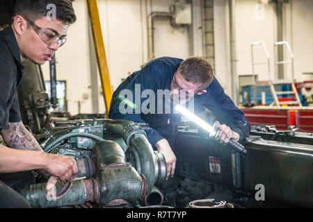 Première Classe pilote américain Devin Johnson (à droite), un mécanicien de véhicule avec le 139e Escadron de préparation logistique, New York Air National Guard, effectue la maintenance du moteur d'un Tunner 60K Chargeur, lors d'une formation sur le terrain de déploiement à base aérienne de Ramstein, en Allemagne, le 6 avril 2016. Plus de 40 139 aviateurs avec LRS étaient aux côtés de leurs homologues de la 86e Escadre de mobilité aérienne afin d'améliorer leurs niveaux de compétences au sein de leur carrière. Base aérienne de Ramstein est le foyer de la 86e, 435e et 721e l'aéromobilité ailes qui soutiennent trois théâtres : United States Africa Command, le Commandement Central Banque D'Images