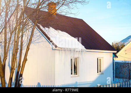 La petite maison avec des glaçons. La construction résidentielle sur une journée d'hiver, un peu de neige sur le toit au soleil, horizontal tourné Banque D'Images