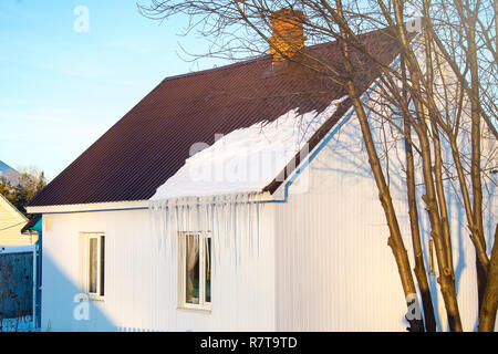 La petite maison avec des glaçons. La construction résidentielle sur une journée d'hiver, un peu de neige sur le toit au soleil, horizontal tourné Banque D'Images