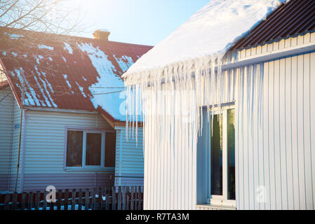 La petite maison avec des glaçons. La construction résidentielle sur une journée d'hiver, un peu de neige sur le toit au soleil, horizontal tourné Banque D'Images