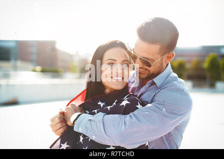 Jeune homme embrassant belle petite amie avec USA flag, le bonheur Banque D'Images