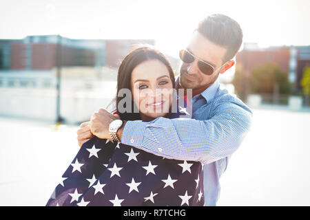 Jeune homme embrassant belle petite amie avec USA flag portrait, le bonheur Banque D'Images