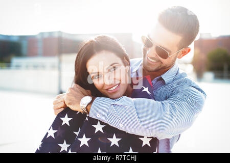 Jeune homme embrassant belle amie avec smile USA flag, le bonheur Banque D'Images