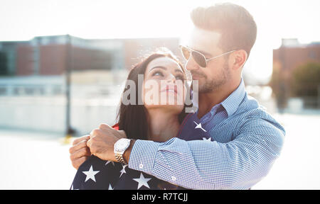 Jeune homme embrassant belle petite amie avec USA flag, le bonheur jusqu'à la Banque D'Images