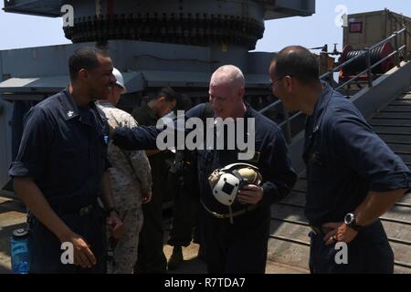 5ème ZONE DES OPÉRATIONS DE LA FLOTTE (4 avril 2017) Le lieutenant Cmdr. Diego H. Londono, droite, et spécialiste des programmes religieux 1re classe Jeffery Fulson, gauche, saluer le lieutenant Cmdr. Jay Kersten à son arrivée à bord du navire de débarquement quai amphibie USS Carter Hall (LSD 50) pour fournir Messe catholique romaine dans la célébration de l'Eucharistie pour l'équipage du navire dans la chapelle de Gator. Le navire est déployé avec le groupe amphibie Bataan dans la 5e flotte américaine zone d'opérations à l'appui d'opérations de sécurité maritime visant à rassurer les alliés et les partenaires et de préserver la liberté de navigation Banque D'Images