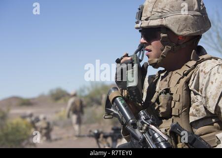 Le Corps des Marines des États-Unis. Bryan T. Vanhoose, un chef d'équipe avec 2e peloton, Compagnie Echo, 2e Bataillon, 6e Régiment de Marines, 2e Division de Marines (2d MARDIV), communique l'emplacement de son équipe au moyen d'une radio au cours de l'attaque au niveau du peloton de tir réel à pâturer sur champ de tir de l'armée américaine pour Yuma (TalonEx Exercice Talon) 2-17, Yuma, A.Z., le 2 avril 2017. Le but d'TalonEx a été pour les unités de combat à mener une formation intégrée à l'appui de l'armes et tactiques - Instructeur (WTI) 2-17 hébergé par Marine Aviation armes et tactiques d'un escadron (MAWTS-1). Banque D'Images