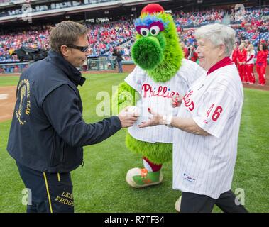 Philadelphie (7 avril 2016) Chef Opérateur Spécial Bill Brown, membre de l'Équipe de parachutistes de la Marine américaine, le saut des grenouilles, donne la première balle à Sylvia Green, épouse de feu Dallas Green, avant le match d'ouverture Accueil des Phillies de Philadelphie. L'Équipe de parachutistes de la Marine est basé à San Diego et effectue des démonstrations de parachutisme aériens autour de la nation à l'appui d'opérations spéciales de la Marine et de recrutement pour la Marine. Banque D'Images