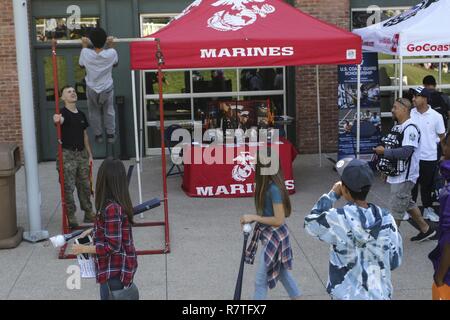 Le s.. Jeremy Matt aide un jeune Padres ventilateur sur la barre de traction, les, le 1 avril 2017, au Petco Park, San Diego, Californie, au cours de la Fan Fest des Padres. Les fournisseurs locaux, les aumôniers et les joueurs employés sont venus célébrer la nouvelle saison avec de la nourriture, de la musique et des jeux. Matt, de Denham Springs, en Louisiane, est un musicien du Marine Corps la liaison avec la Station de recrutement du Corps des Marines de San Diego, 12e District du Marine Corps, de l'Ouest, région de recrutement Le recrutement du Corps des Marines. Banque D'Images