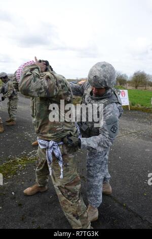 Des soldats américains affectés au 39e Bataillon du signal, recherche un suspect au cours de l'entrée de la recherche du point de contrôle de l'exercice, commandant de la Base Aérienne de Chièvres, Belgique, le 21 mars 2017. Banque D'Images