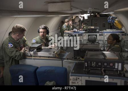 U.S. Air Force d'un membre de la 1re classe Favian Arteaga, 961e Airborne Air Control Squadron technicien de surveillance aéroporté (à gauche), utilise un système de communication le 28 mars 2017, alors qu'il volait dans un E-3 Sentry sur l'océan Pacifique. La surveillance aérienne des techniciens effectuent l'identification initiale des Ami ou ennemi des avions et de surveiller leur position. Banque D'Images