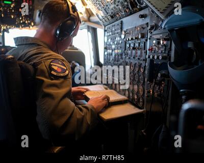 Un mécanicien de l'US Air Force à partir de la 961e Airborne Air Control Squadron surveille les E-3 Sentry Aircraft Systems le 28 mars 2017, alors qu'il volait dans un au-dessus de l'océan Pacifique. L'ingénieur de vol est le seul pilote qui s'opère dans le cockpit du Sentry et agit comme un pont entre le poste de pilotage et la mission de l'équipage. Banque D'Images