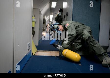 Le sergent de l'US Air Force. Anthony Aranda, 961e Escadron de l'air en suspension dans l'air, technicien radar inspecte un aéronef E-3 Sentry pour les dommages lors d'une dépressurisation rapide 28 Mars, 2017 de forage, tout en survolant l'océan Pacifique. Les techniciens radar peut prendre différents rôles, comme un pompier, à l'intérieur de la zone de l'équipage de la mission en cas d'urgence. Banque D'Images