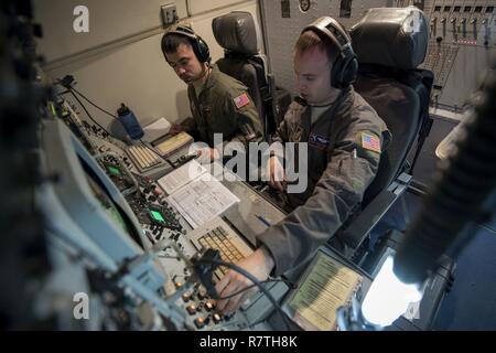 Le sergent de l'US Air Force. Anthony Lambrechts, 961e Airborne Air Control Squadron technicien en communication (à gauche) et SSgt. Michael Burch, 961e système de communication AACS, opérateur de procéder à un balayage des communications le 28 mars 2017, lors d'une mission de formation sur l'océan Pacifique. Fournir le soutien des communications radio des aviateurs à l'équipage, permettant un moyen sécurisé pour communiquer avec les avions et en partenariat avec différents organismes du sol. Banque D'Images