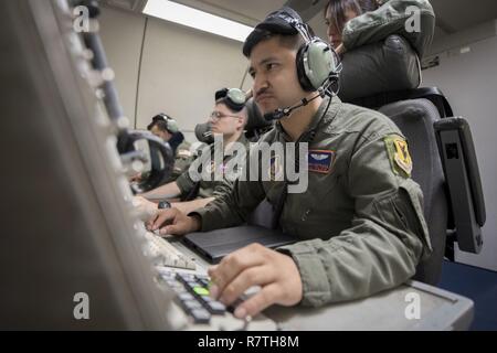 U.S. Air Force d'un membre de la 1re classe Favian Arteaga, 961e Airborne Air Control Squadron technicien de surveillance aéroporté, utilise un système de communication le 28 mars 2017, alors qu'il volait dans un E-3 Sentry sur l'océan Pacifique. Les techniciens de surveillance détecter, suivre et identifier les avions amis et ennemis et de transmettre toutes les informations pertinentes à la commande de l'air en suspension dans l'équipe du contrôleur système. Banque D'Images