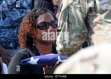 Deshana Pandy reçoit un drapeau américain à partir de la commande le Sgt. Grand Angel Rivera dans un salon funéraire détail pour son père, 22 ans, vétéran de l'Armée Le sergent-chef. David Daniel Alexander Pandy Jr., à un cimetière à Ladyville Belize, le 30 mars 2017. Le sergent-major est un réserviste de Puerto Rico du 210e groupe d'appui régional affecté à au-delà de l'horizon 2017-BELIZE, Belize un exercice de partenariat englobant trois événements de santé et cinq projets de construction visant à améliorer l'infrastructure de santé et d'éducation des communautés bélizienne. Banque D'Images