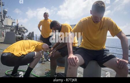 Mer de Chine du Sud (8 avril 2017) (De gauche à droite) Technicien électronique Seaman Joel Reid, spécialiste culinaire 1re classe Wilson Ebreo, canonniers Mate Matelot Tyler Suggs, incendie et Controlman 3e classe Joseph MacFarland décontaminer après avoir été exposés à l'oléorésine de capsicum au cours de la formation des forces réactionnaires de la sécurité à bord de la classe Arleigh Burke destroyer lance-missiles USS Stethem (DDG 63). Stethem est en patrouille en mer de Chine du Sud soutenir la sécurité et la stabilité dans la région du Pacifique-Indo-Asia. Banque D'Images