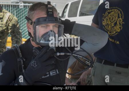 Plongeur de la marine américaine 1ère classe Duane Altman, affecté à la plongée et Mobile Salvage Company 11-7, vérifie le joint sur masque de visage dans le cadre de vérifications avant de plonger le 4 avril 2017 sur la base navale de San Diego, en Californie. Société de sauvetage et de plongée Mobile 11-7 a pris part aux efforts visant à démonter et enlever une barge partiellement à partir de la baie de San Diego. Banque D'Images