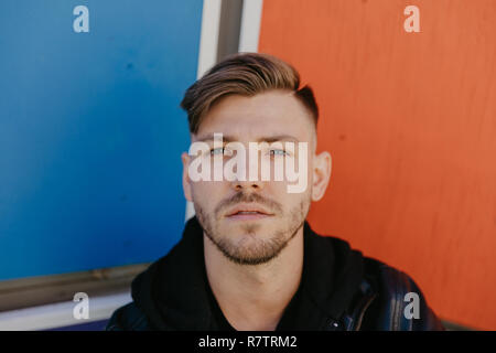 Beau mâle attrayant modèle personne adultes en Hiver Saison d'automne des coups de tête vers le haut Fermer Portraits Expression grâce à ses couleurs vives fond peint Banque D'Images