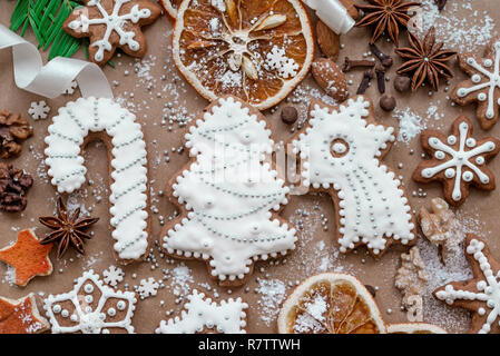 Décoration de Noël avec des épices et des biscuits en forme de flocons de neige sur fond de papier brun foncé. Vue d'en haut. Banque D'Images