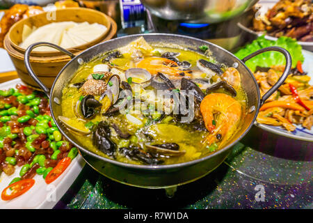 De délicieux plats de fruits de mer chinois aux crevettes palourdes dans un pot de fer Banque D'Images