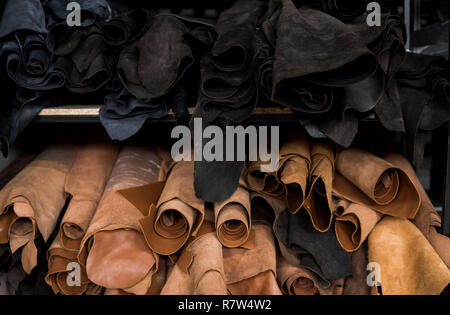 Les différentes pièces de cuir dans une Rolls. Les morceaux de la couleur du cuir. Rouleaux de noir et brun naturel et autres articles en cuir. Matières premières pour manu Banque D'Images