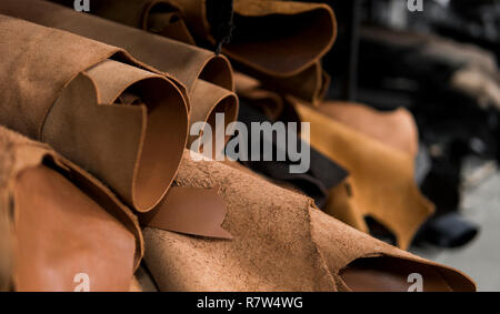 Les différentes pièces de cuir dans une Rolls. Les morceaux de la couleur du cuir. Rouleaux de cuir rouge brun naturel. Matières premières pour la fabrication de sacs, Banque D'Images