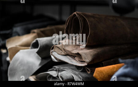 Les différentes pièces de cuir dans une Rolls. Les morceaux de la couleur du cuir. Rouleaux de noir et brun naturel et autres articles en cuir. Matières premières pour manu Banque D'Images