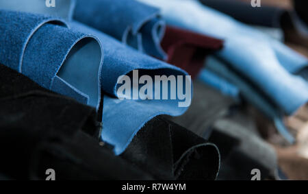 Les différentes pièces de cuir dans une Rolls. Les morceaux de la couleur du cuir. Rouleaux de cuir bleu et noir. Matières premières pour la fabrication de sacs, sh Banque D'Images