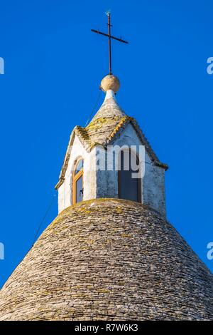 Italie, Pouilles, vallée d'Itria, Alberobello, Site du patrimoine mondial de l'UNESCO pour le district de trulli, habitations faites de pierres sèches avec un toit conique recouvert de lauzes calcaires, Eglise de San Antonio avec son architecture trullo construit en 1926 Banque D'Images